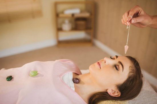 Young woman at crystal healing session in therapy room Young woman at crystal healing session in therapy room